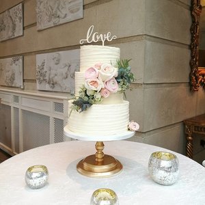 Rustic buttercream wedding cake with fresh flower garnish