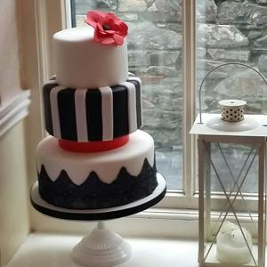 A beautiful 3 tier wedding cake with cake lace on bottom tier and large sugar flower.  Availble in all colours