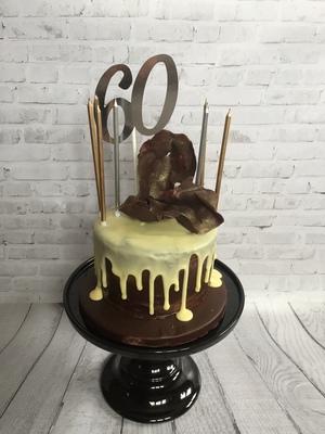 a 6' Chocolate Biscuit Drip Cake with a Chocolate Sail Topper