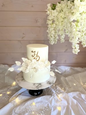 romantic all white wedding cake with gold leafing 
